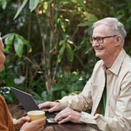 Older couple enjoying coffee at an outdoor cafe.