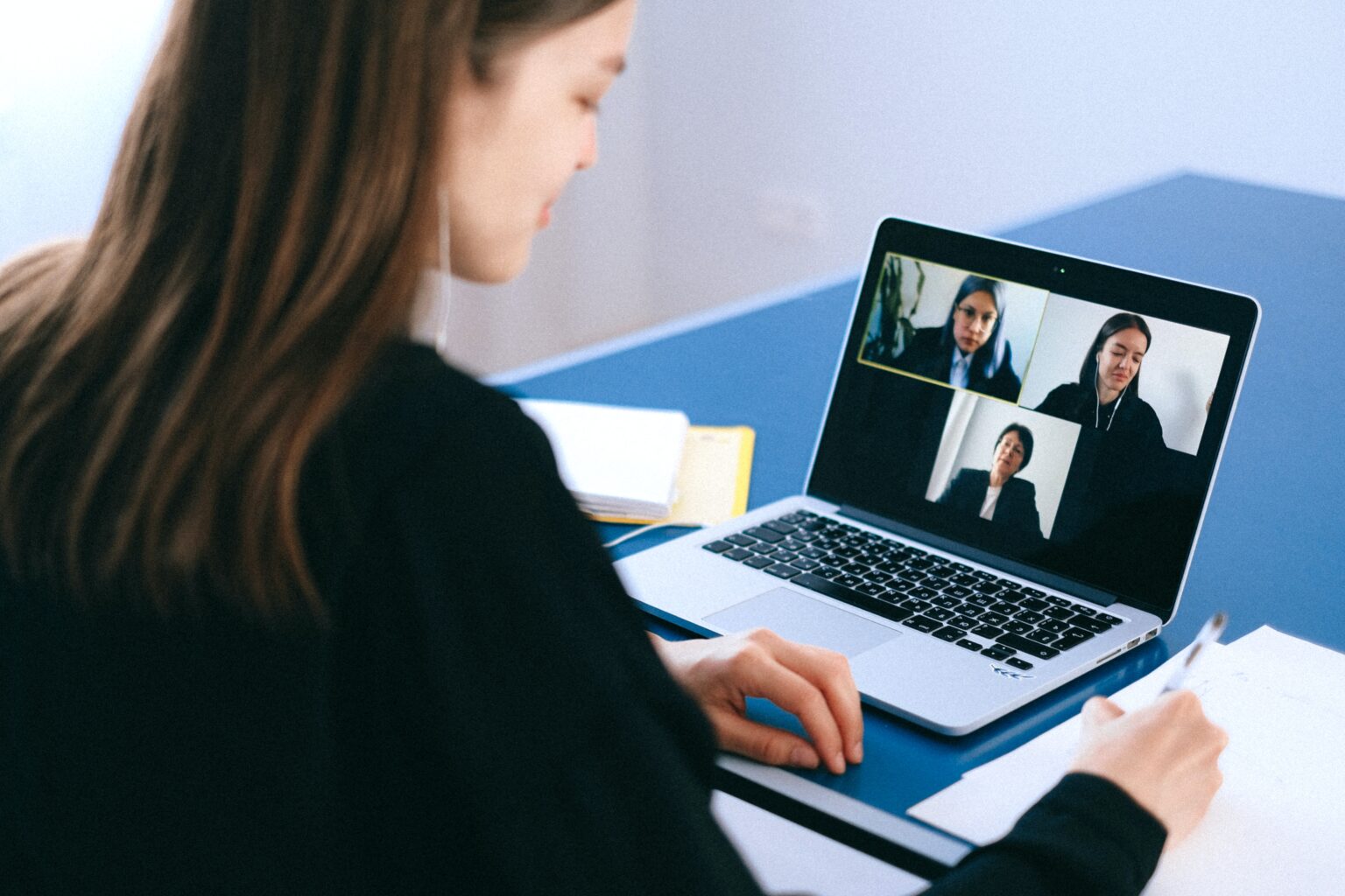 Woman participating in a virtual work meeting on her laptop.