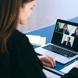 Woman participating in a virtual work meeting on her laptop.