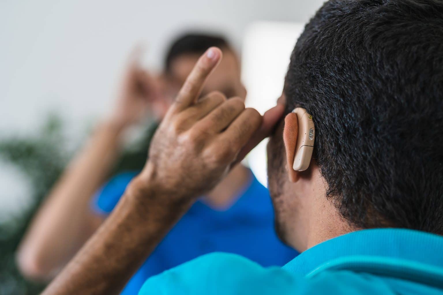 a man with hearing aids looks in the mirror