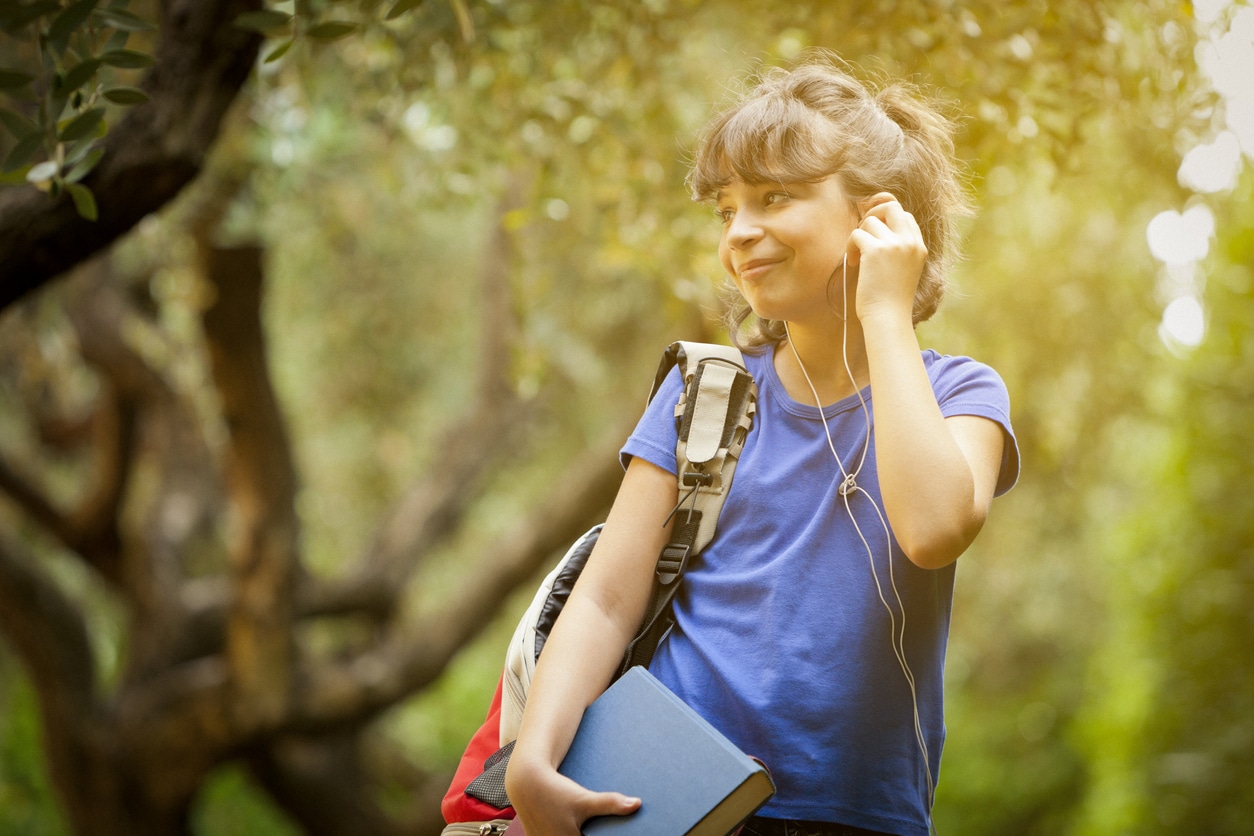 Young girl listens to in-ear headphones