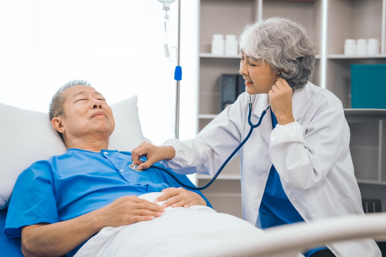 Man in hospital checked by doctor