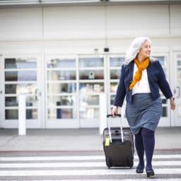 Senior woman carrying a suitcase at the airport