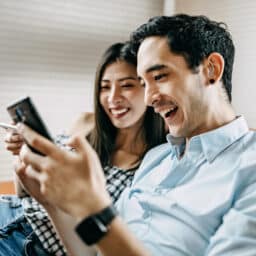 Man wearing a hearing aid and looking at his home with his girlfriend
