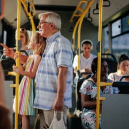 Senior man and granddaughter in public transport