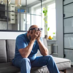 Stressed man sitting with his head in his hands